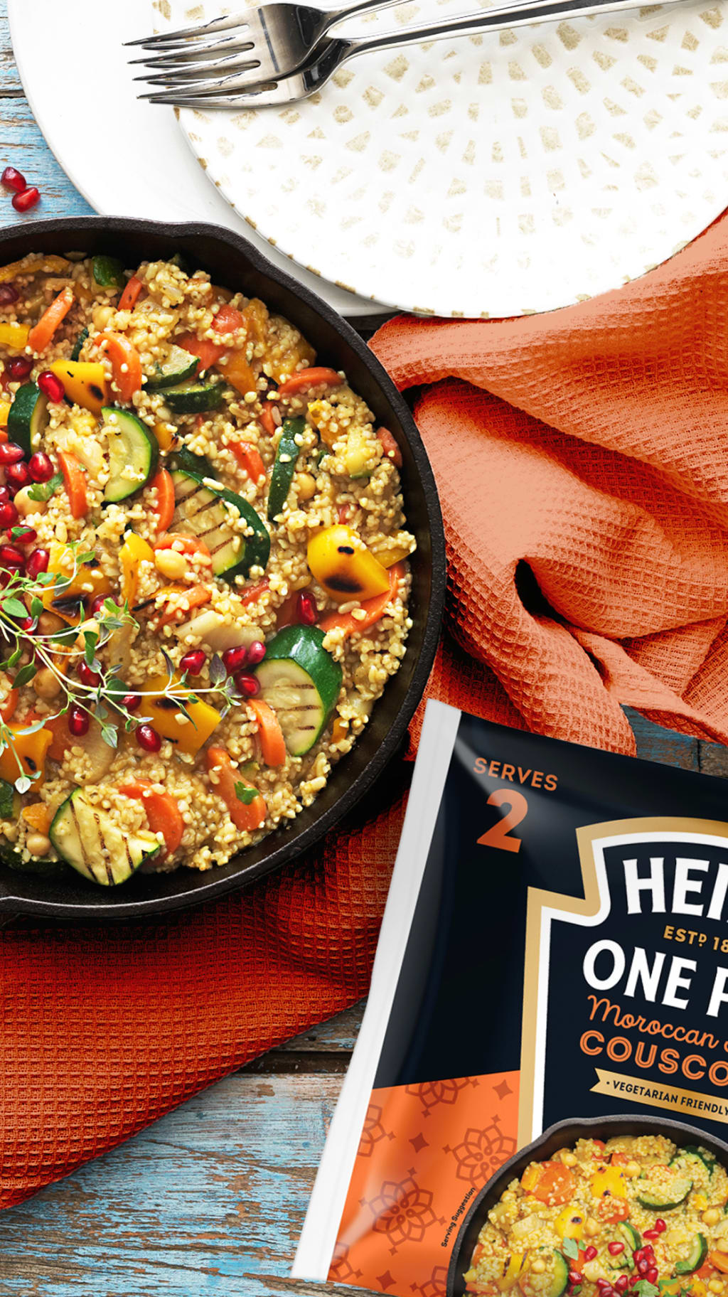 Moroccan couscous with vegetables in a cast iron pan next to a Heinz One Pan package.