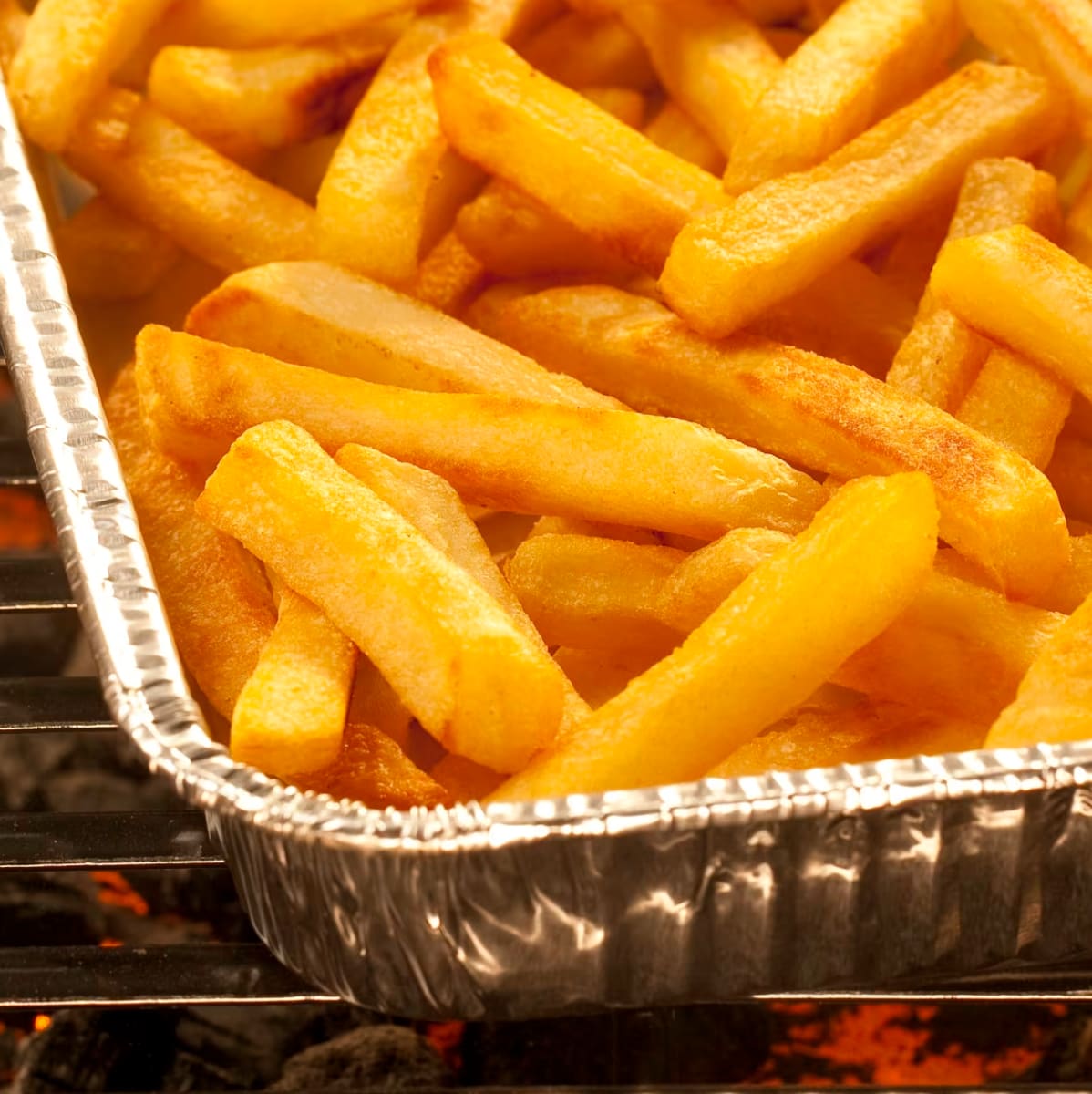 炭火で調理されたアルミ容器に入ったフライドポテト。