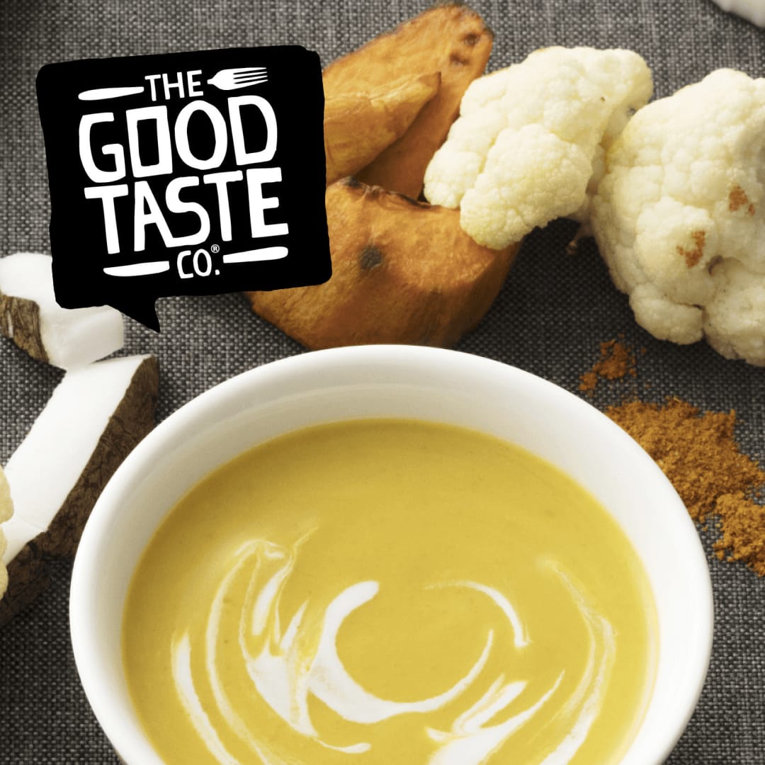 A bowl of Good Taste Co. soup on a table next to its ingredients and spices.