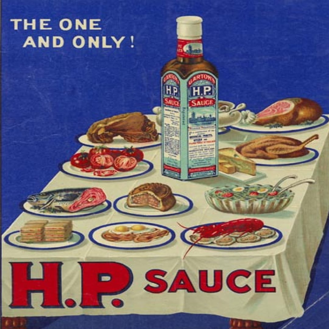 A vintage HP Sauce ad depicting a bottle of sauce on a loaded dinner table.
