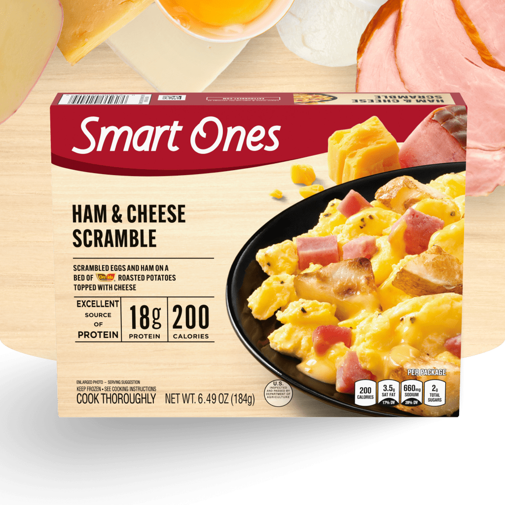 Packaging for Smart Ones Ham & Cheese Scramble. The box shows a plate with scrambled eggs, ham, and cheese. Text highlights 1