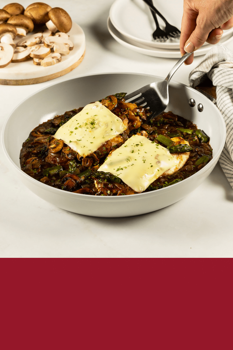 A fork digging into a dinner of gravy-topped Chicken Mushroom Skillet with HEINZ HomeStyle Brown Gravy.
