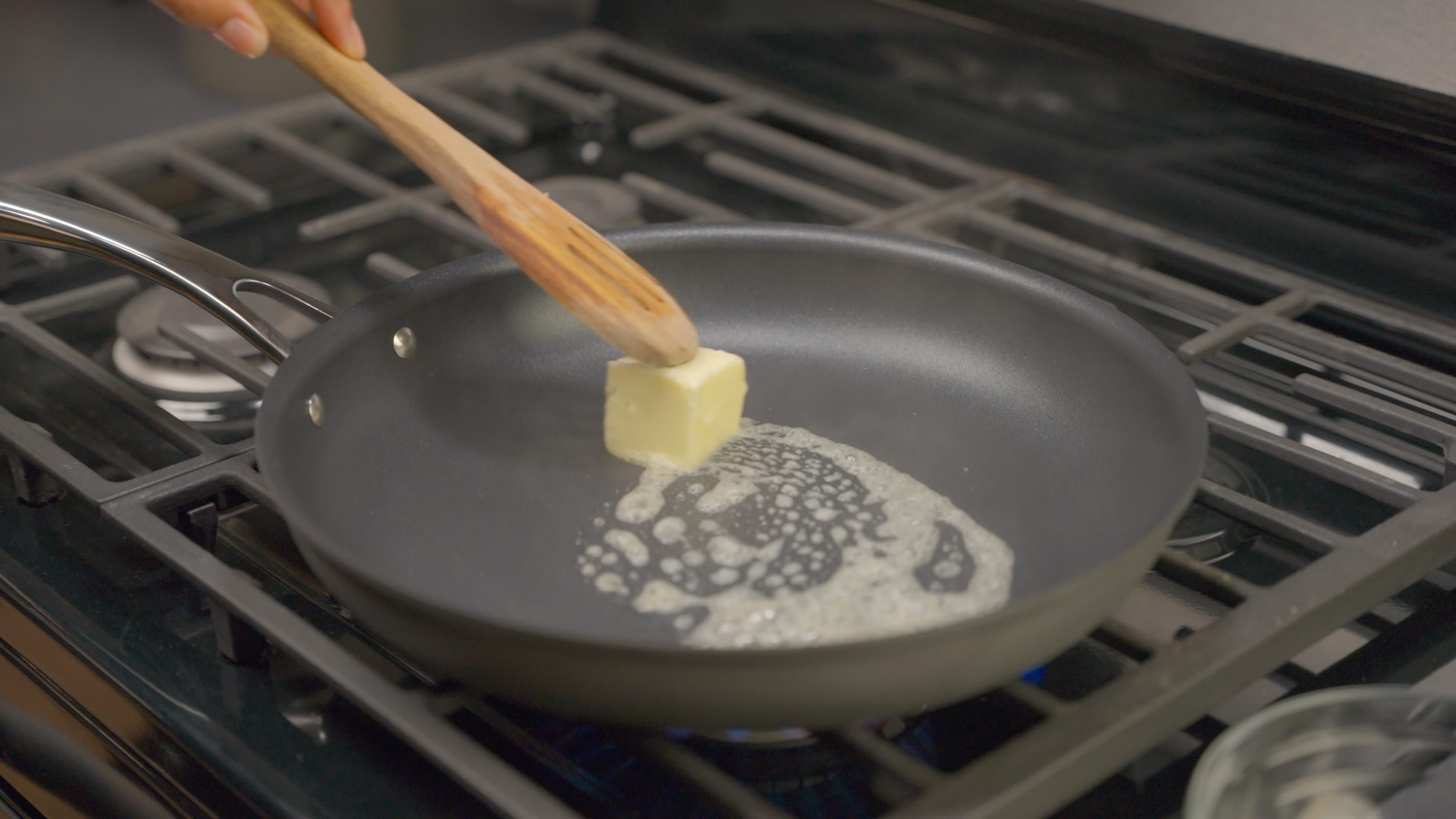 One quarter cup of butter is melting in a large skillet over medium heat.