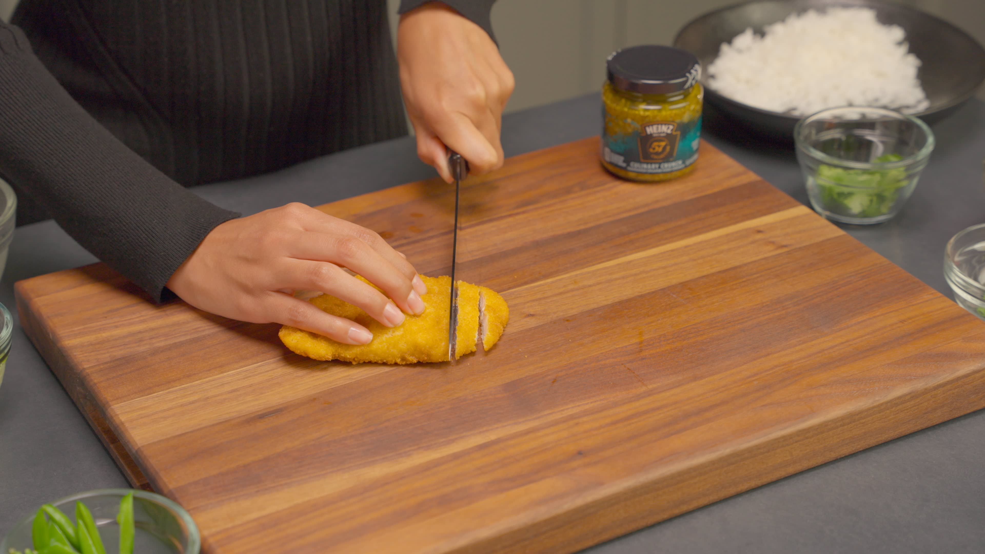 The baked chicken is sliced and placed on a plate full of rice.
