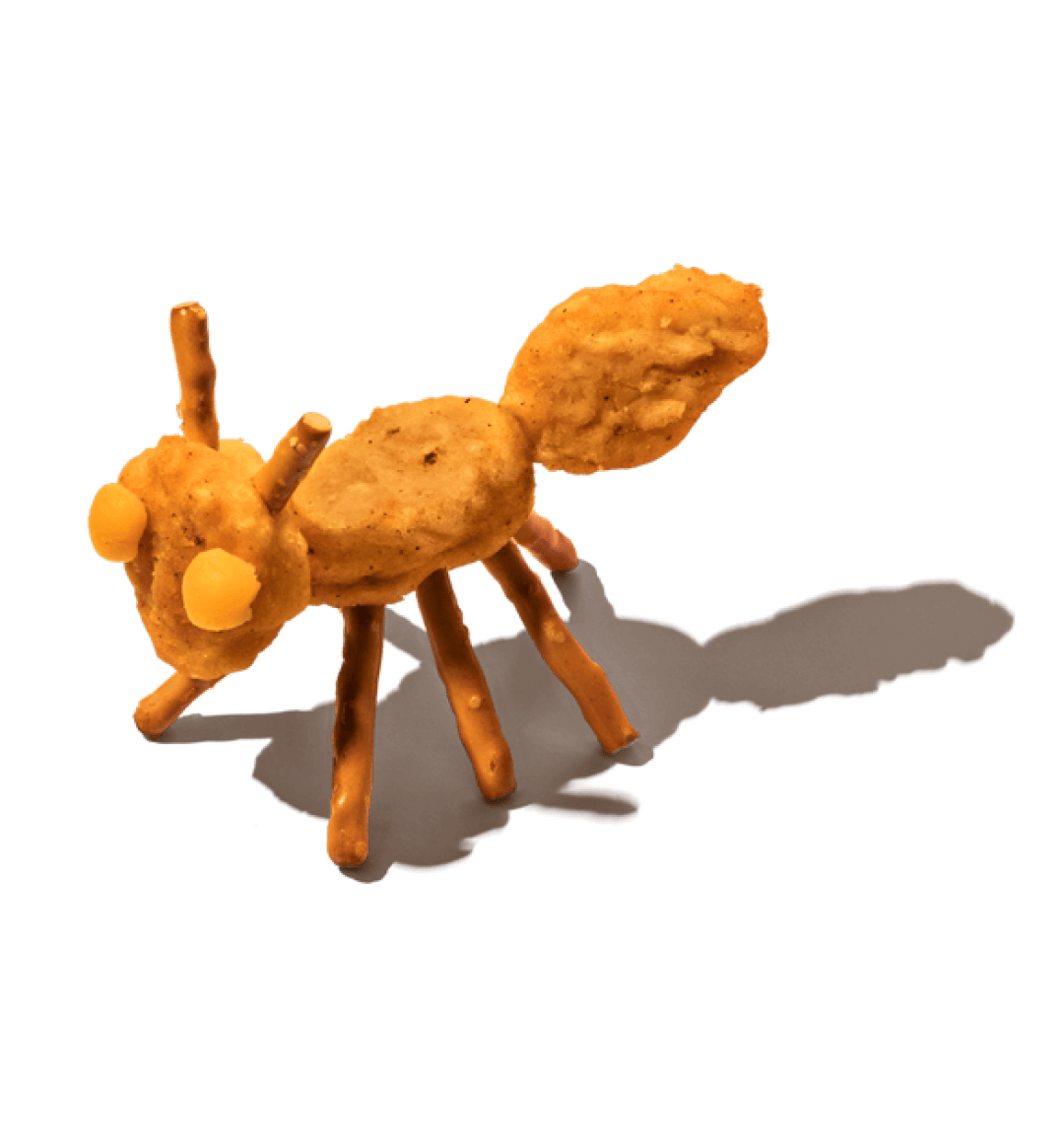 An ant made of snack foods, on a black background.