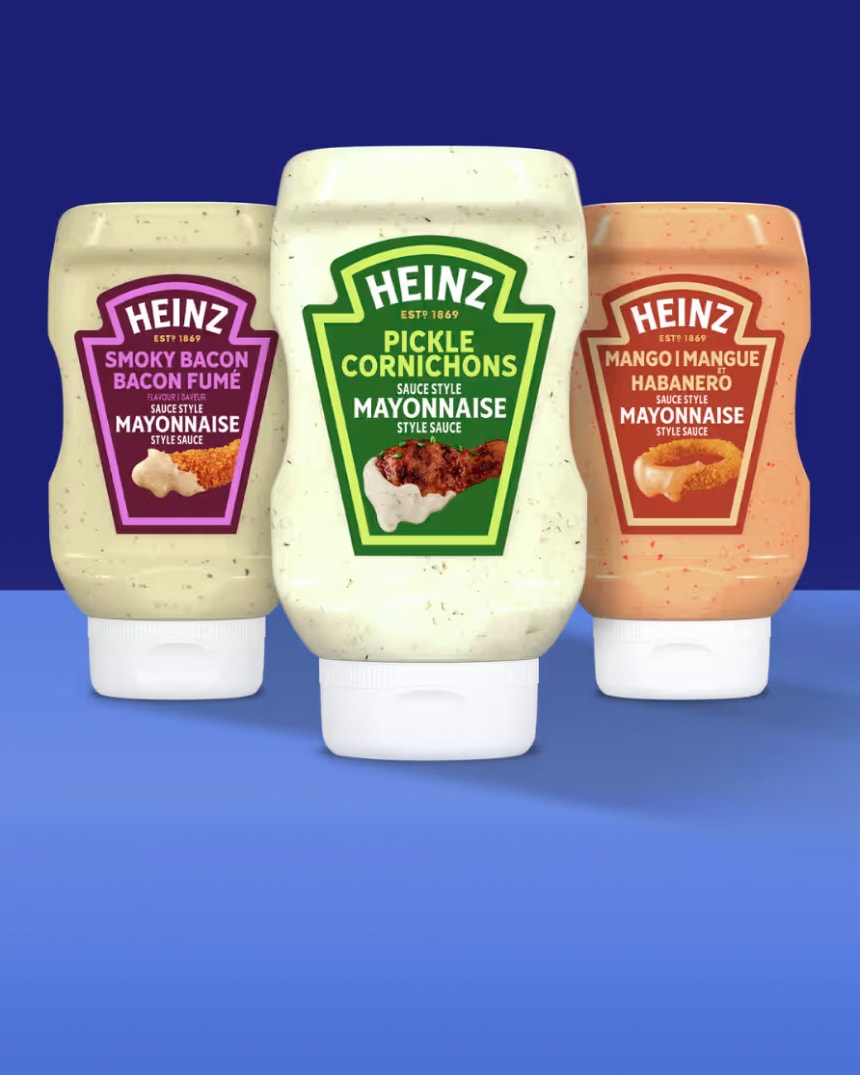 Three bottles of Heinz mayonnaise-style sauces: Smoky Bacon, Pickle, and Mango Habanero, against a blue background.