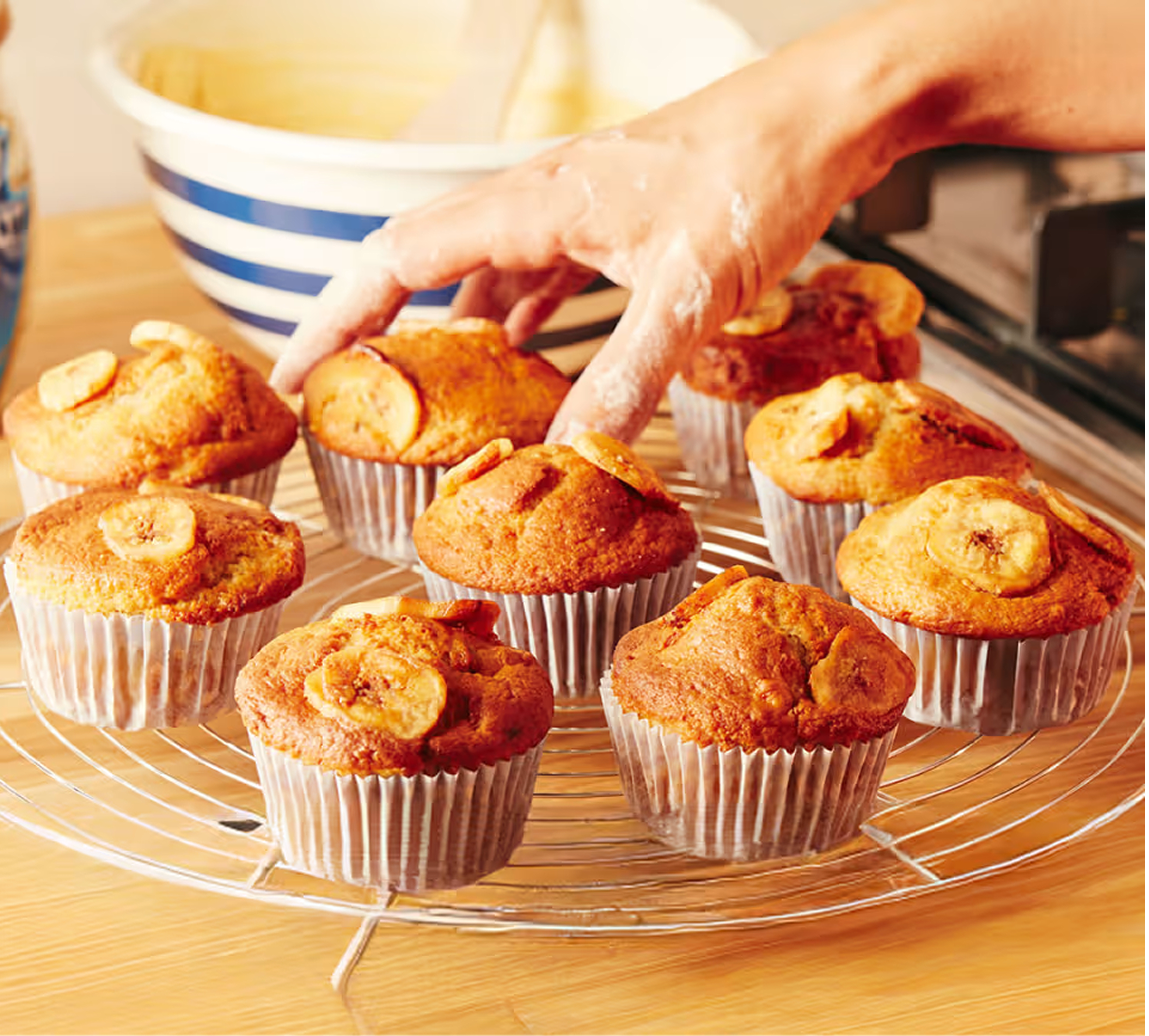 Uma visão deliciosa de muffins de banana recém-assados, dispostos em uma gradinha de resfriamento sobre uma bancada de madeir