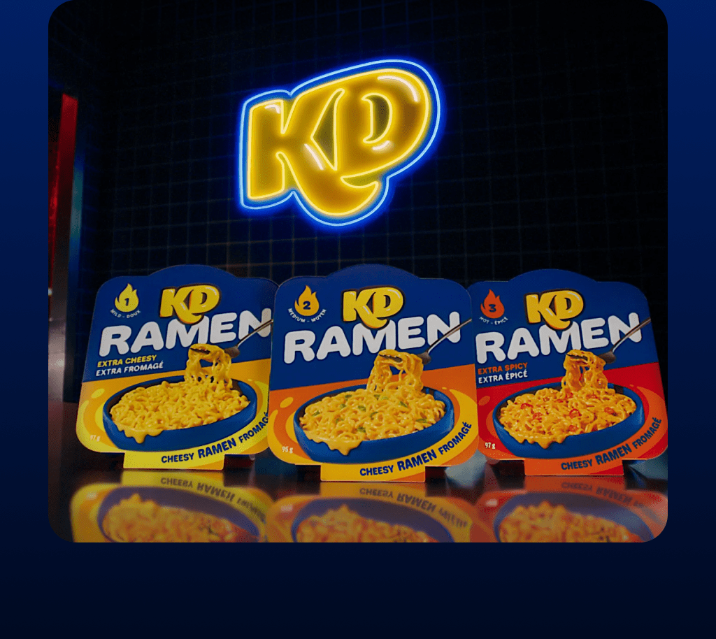 Trois variétés de Ramen KD — Doux, Moyen et Épicé — présentées sous un logo néon KD brillant dans un décor sombre et moderne.