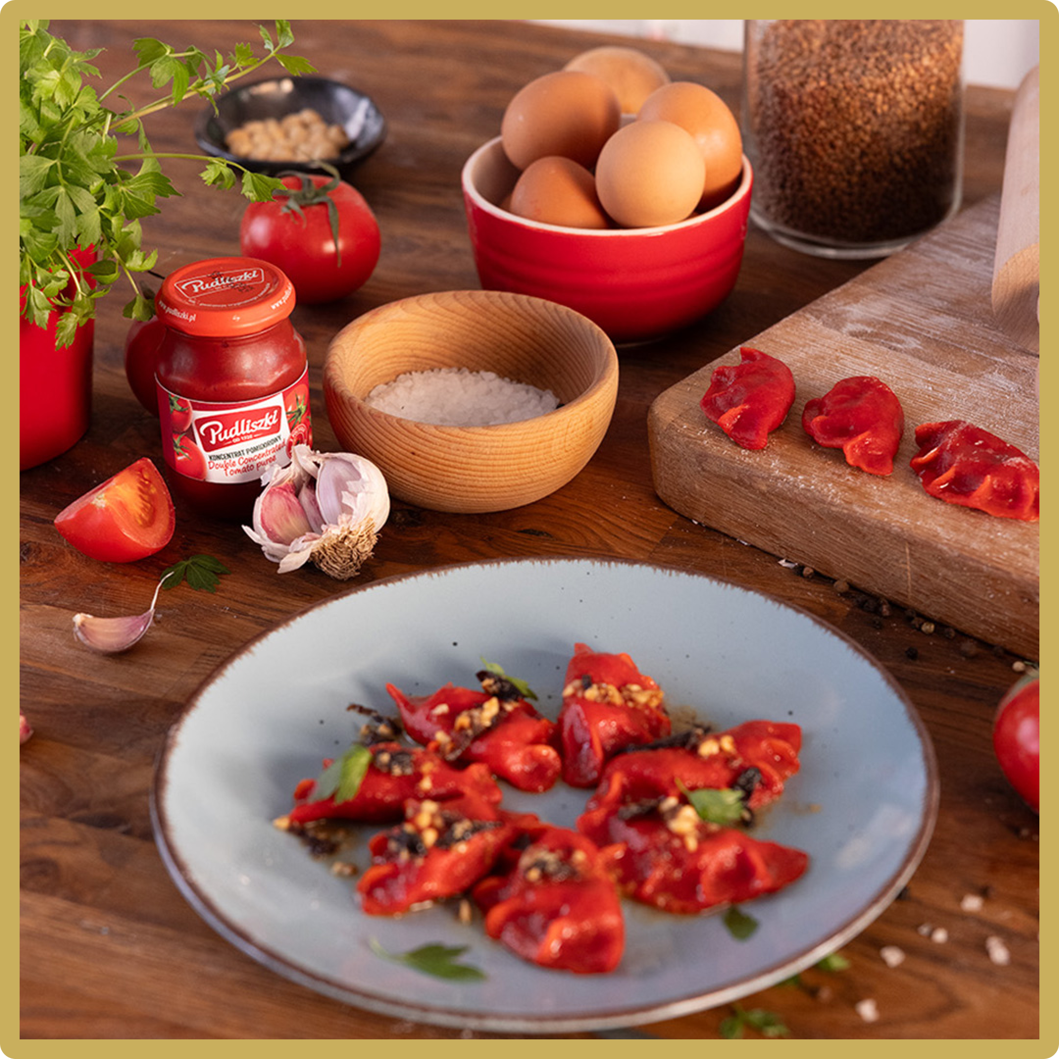 Talerz z czerwoną papryką, pomidorami, czosnkiem i jajkami na drewnianym stole.
