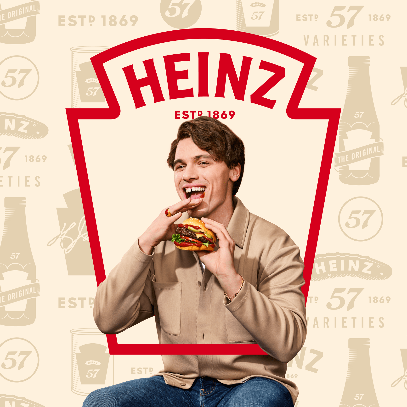 A smiling man about to take a bite of a burger, with the Heinz logo overlaid on the image.