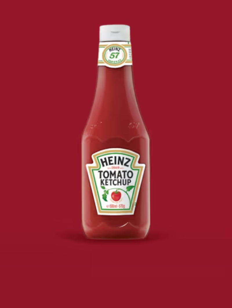 En flaska ketchup mot en röd bakgrund