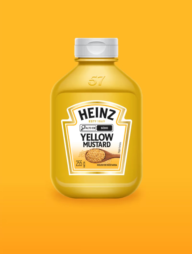 Um frasco de Mostarda Amarela Heinz, com uma imagem de sementes de mostarda em uma colher de pau, sobre um fundo amarelo.