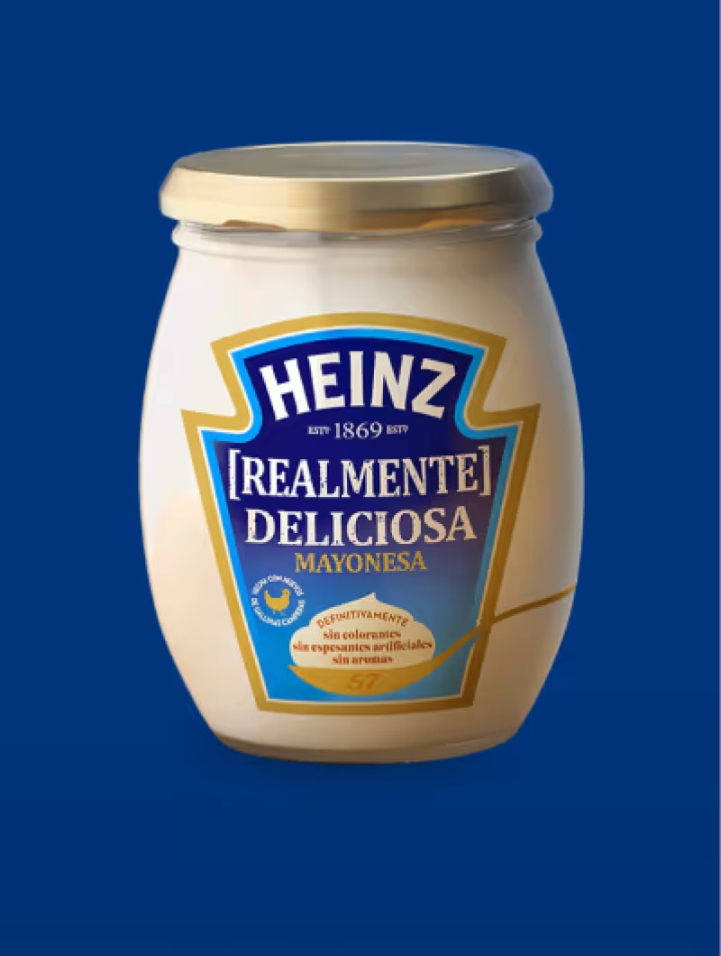 Um frasco de maionese Heinz [Realmente] Deliciosa é mostrado contra um fundo azul royal rico e sólido. O frasco é