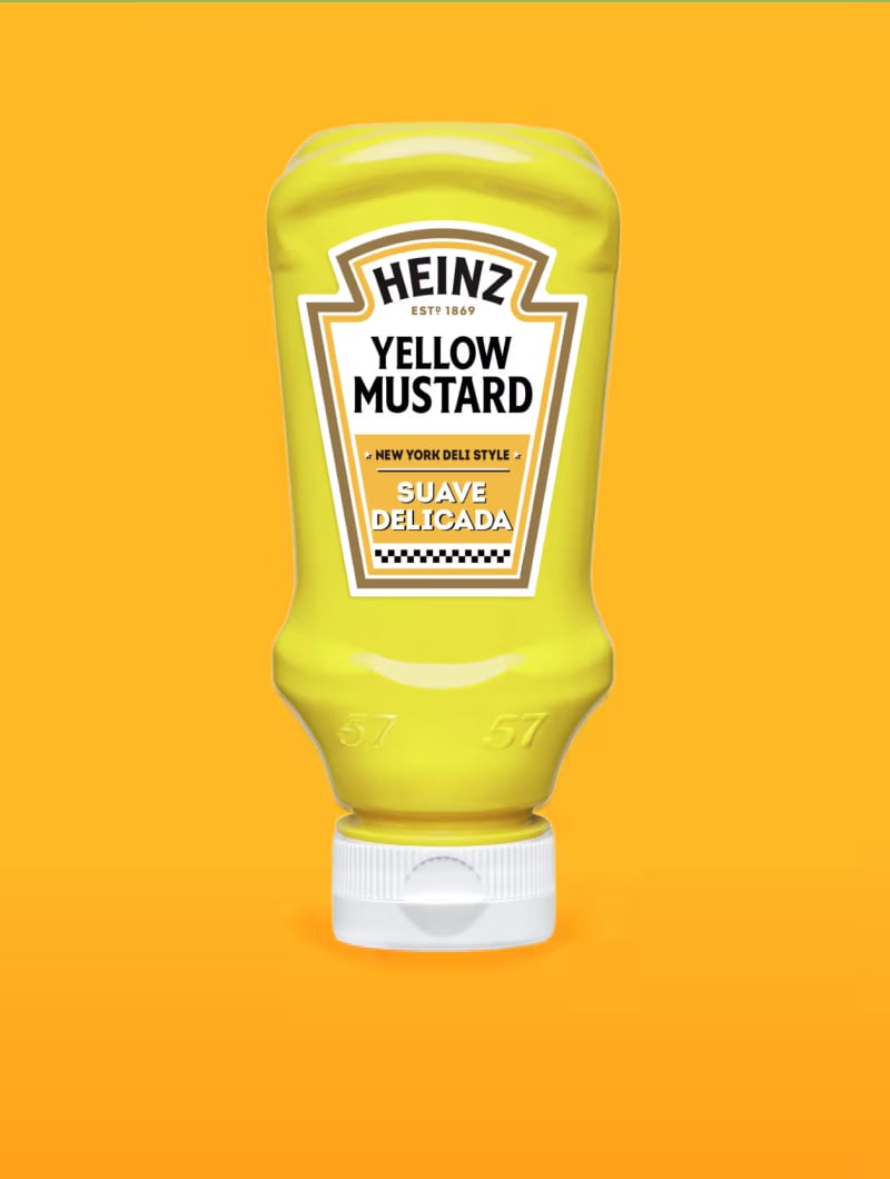 Una botella de Mostaza Amarilla Heinz con tapón blanco sobre un fondo naranja. La etiqueta dice "HEINZ ESTD 1869 Y".