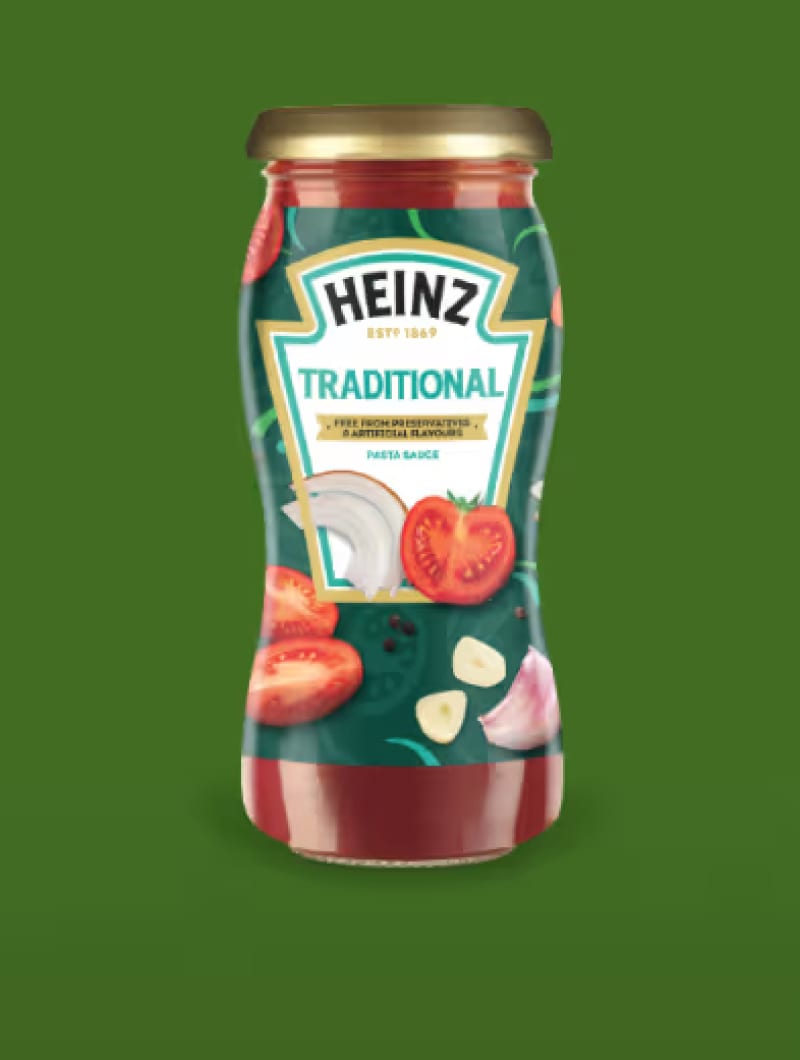 Een glazen bokaal Heinz Traditional Pasta Sauce. Op het etiket staat het Heinz keystone-logo met "HEINZ ESTD 1869 TRADITIONAL