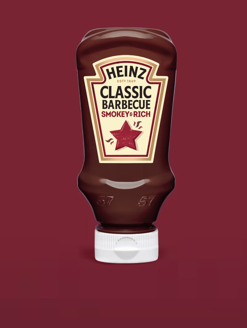 Um frasco invertido de molho Barbecue Clássico Heinz centralizado contra um fundo fosco cor de vinho profundo.