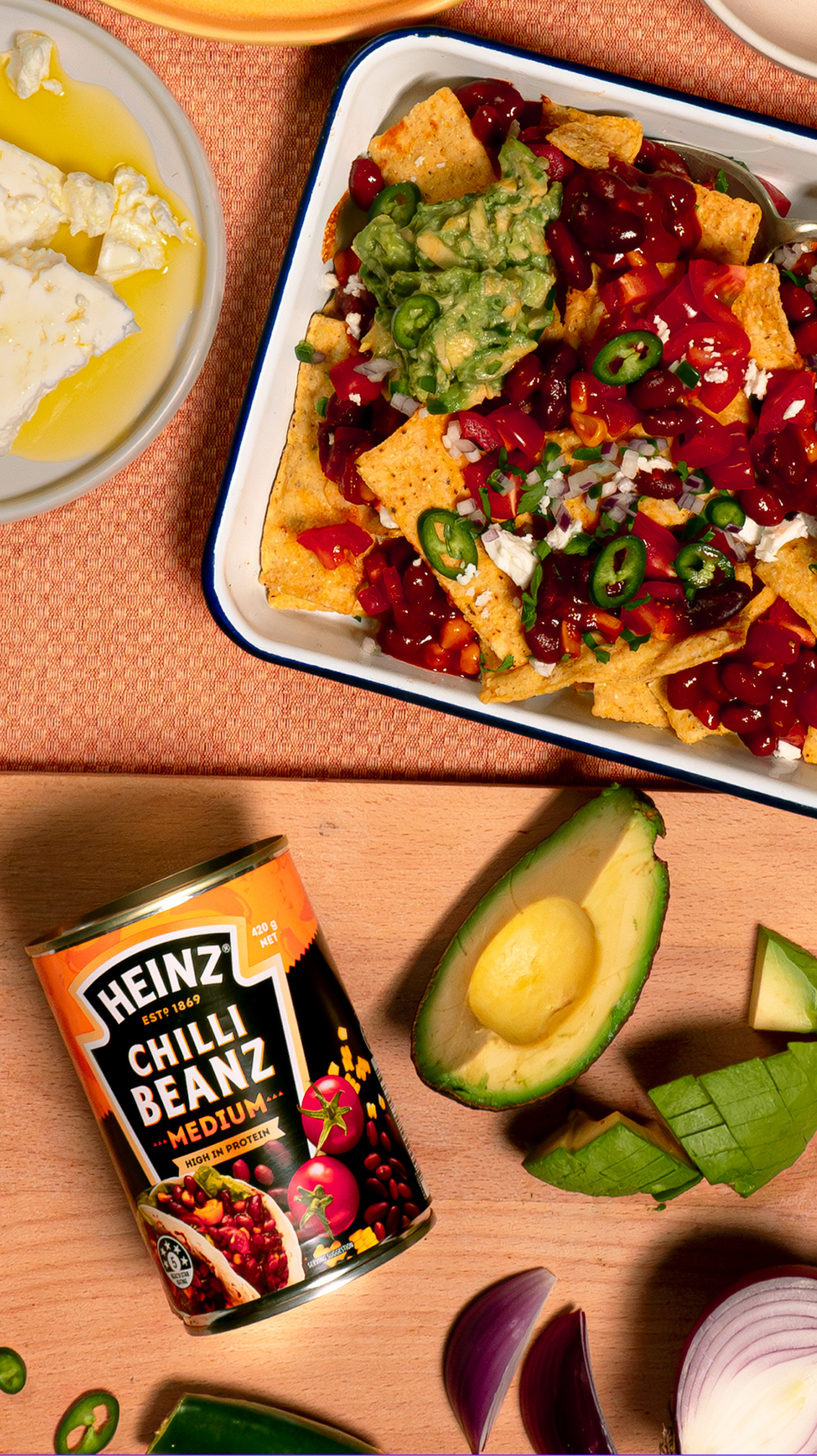 Image of nachos with Heinz chilli beans, avocado, and toppings.