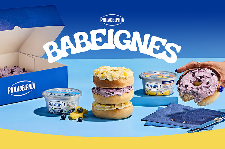 Un assortiment de Babéignes Philadelphia, garnis de fromage à la crème aux bleuets et à l'ananas, présentés à côté de contena