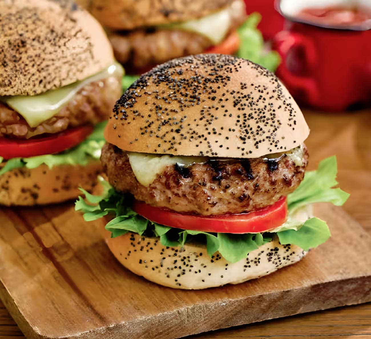 Gros plan de savoureux mini-burgers avec du fromage fondu, de la tomate fraîche, de la laitue et un ingrédient secret Heinz.
