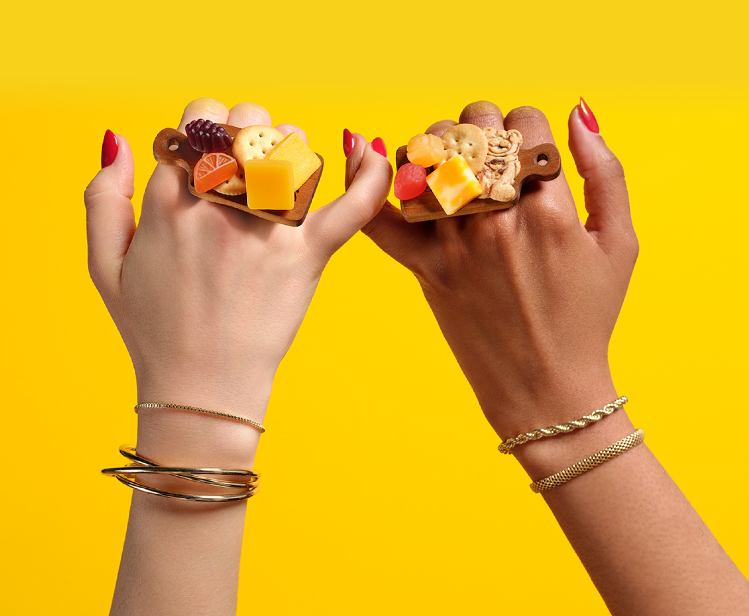 Two hands joined by their pinkies with the Lunchables Charcutering