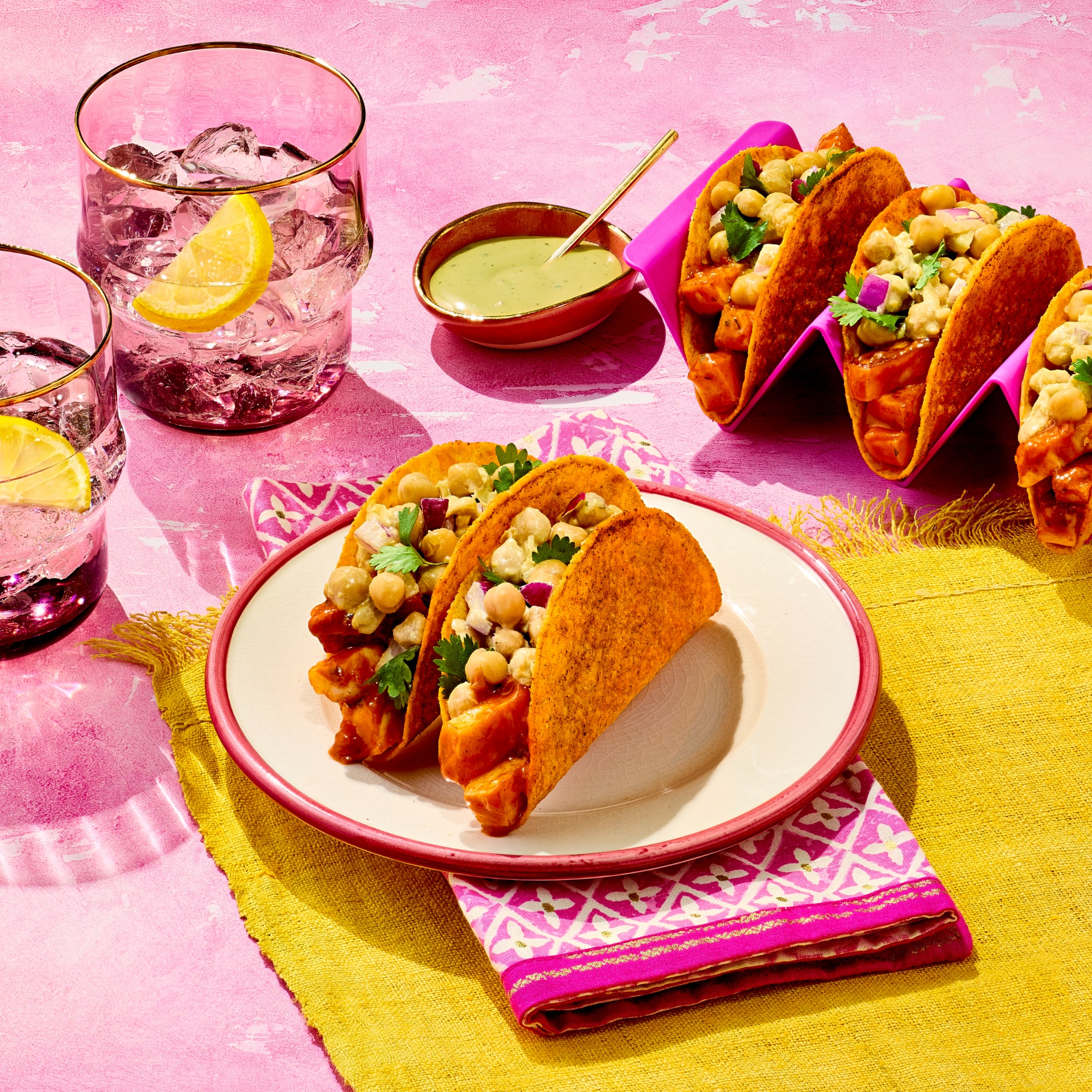 Paneer Tikka Masala Tacos on a plate topped with spiced chickpeas, red onion, and cilantro