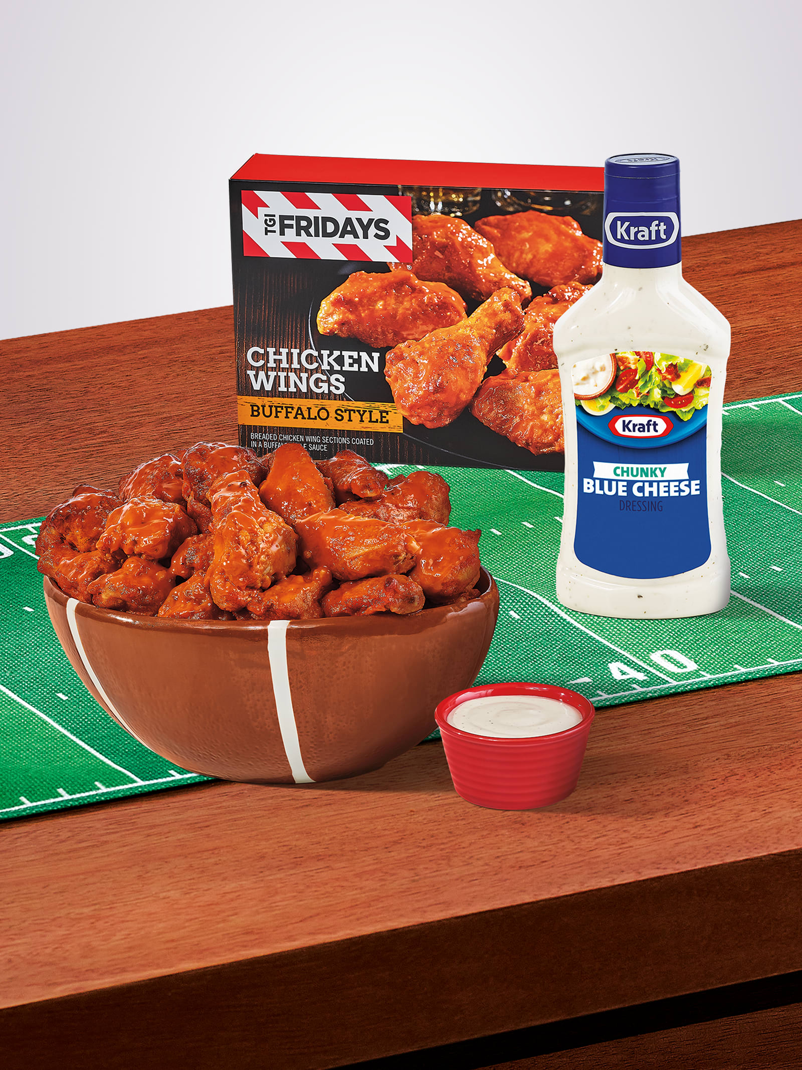 TGI Fridays buffalo chicken wings in a football bowl with Kraft Blue Cheese dressing on a game day field.
