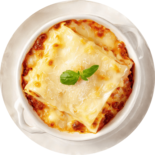 Overhead close-up of a lasagna dish in a white bowl, featuring layers of pasta, rich meat sauce, and bubbly melted cheese. Garnished with a fresh basil sprig and a sprinkle of grated Parmesan.