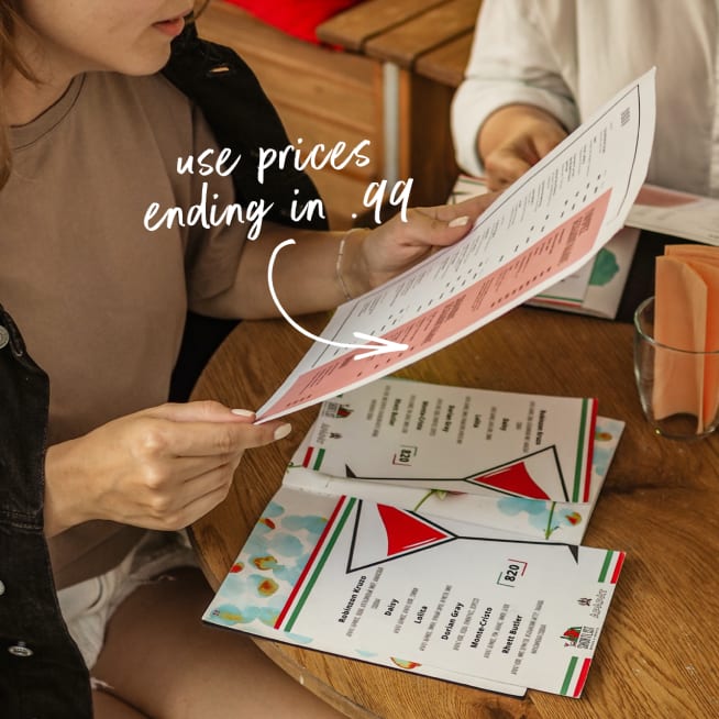 Woman sitting at table looking at a menu