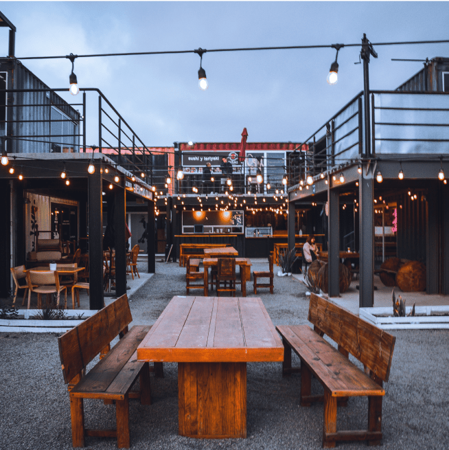 Wooden table and benches on an outdoor patio in front of a restaurant