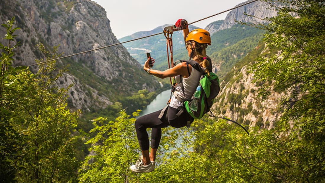 Kvinna �ker zipline i staden Omis, Kroatien