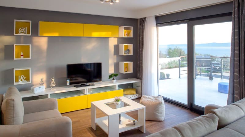 Semesterhus med vardagsrum, tv och terass utanför