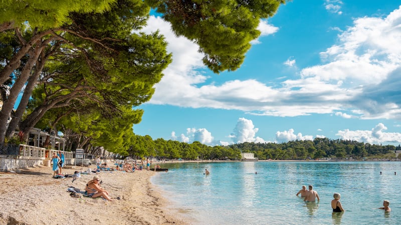 Strand i Makarska med människor som solar