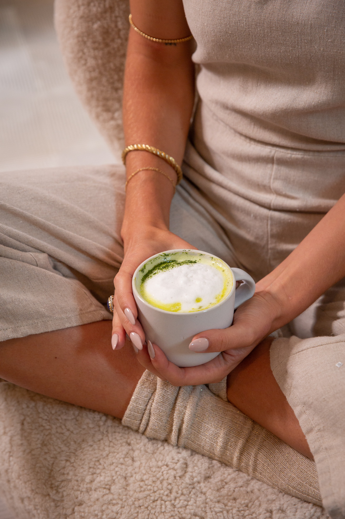 A woman holding a mug of Kroma Beauty Matcha Latte.