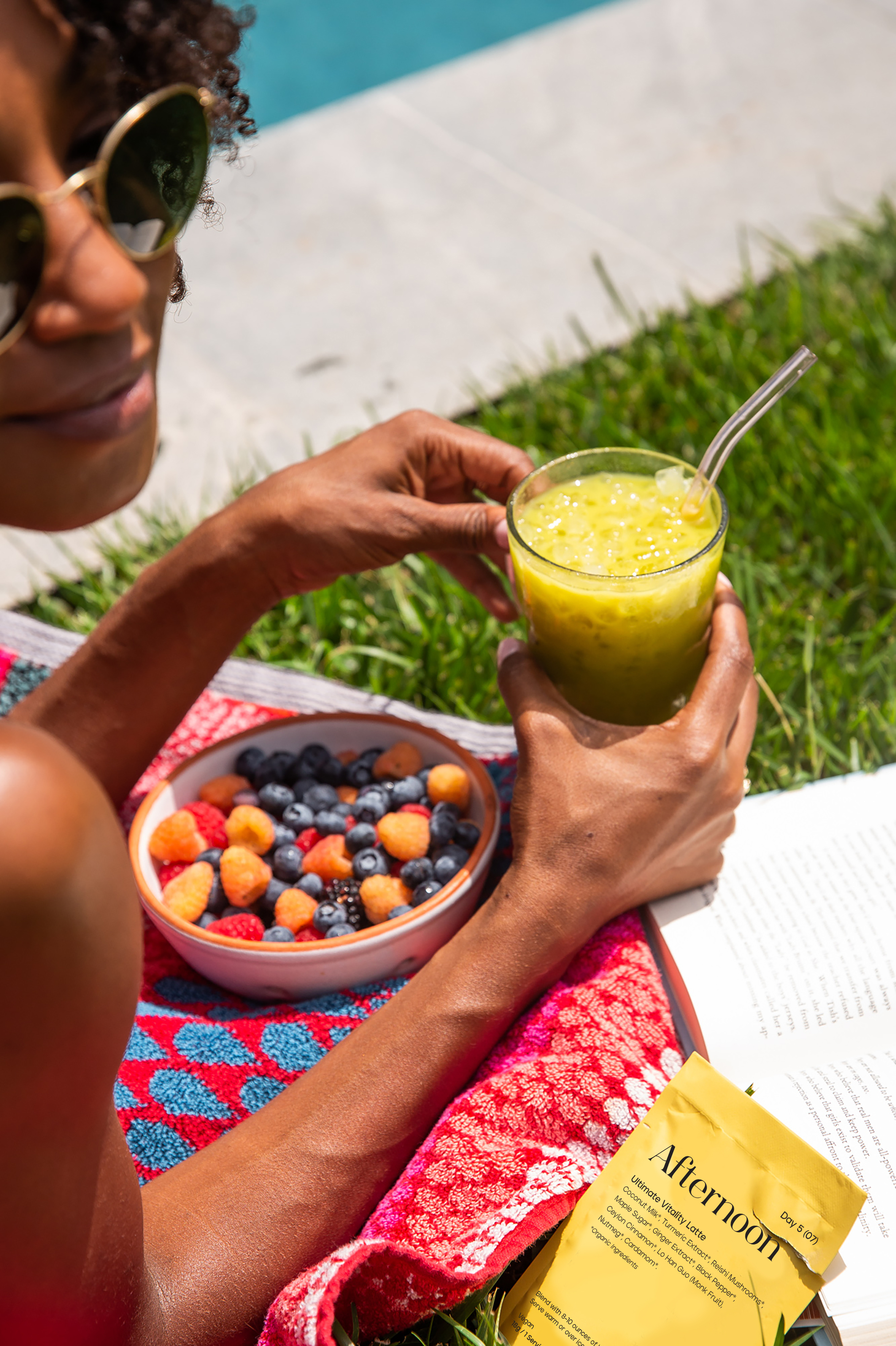 A woman holding a glass of Kroma Ultimate Vitality Latte.