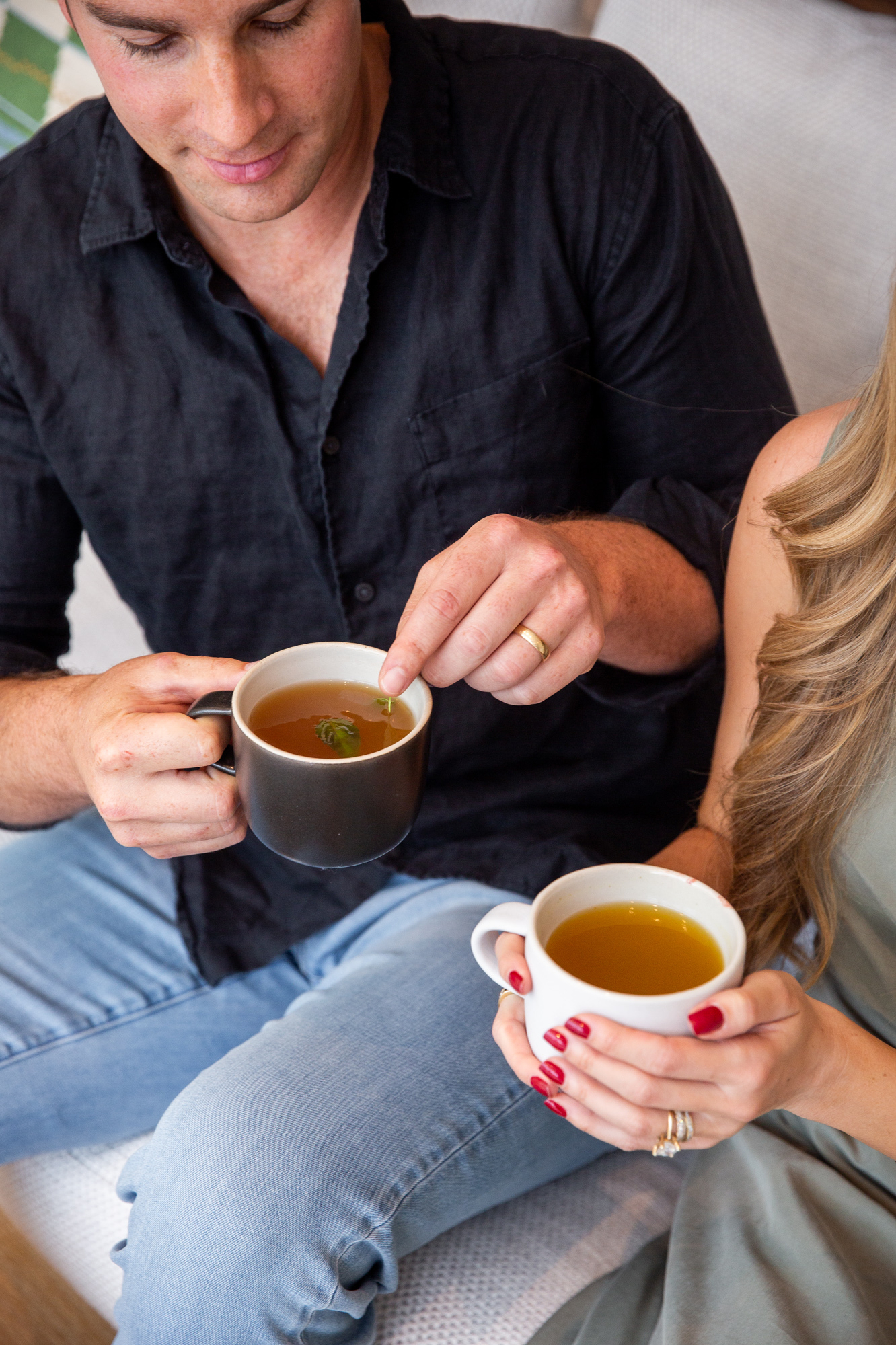 A man and a woman holding two mugs of Kroma 24K Chicken Bone Broth.