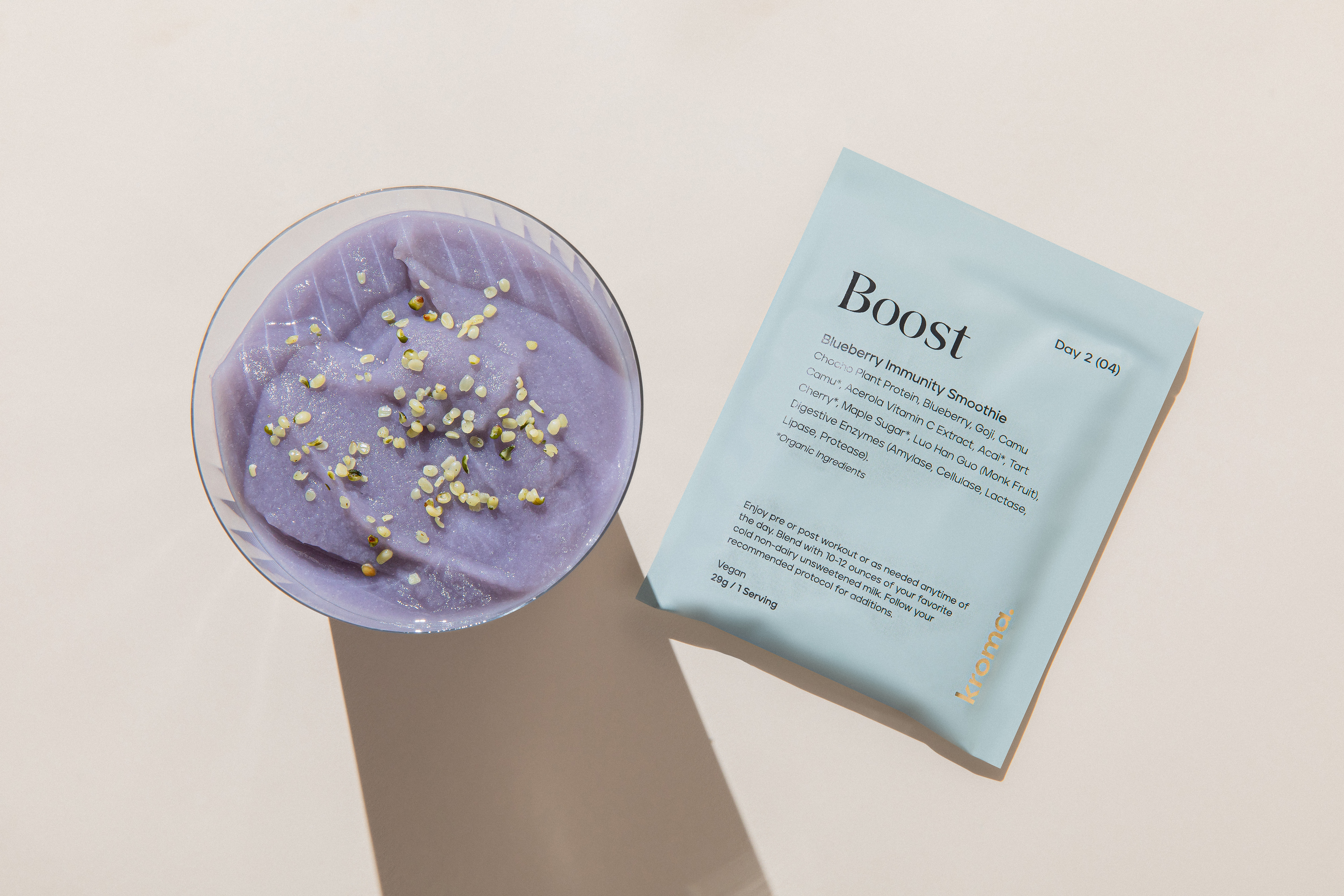 A glass of Blueberry Acai Plant Protein Smoothie with sachet.