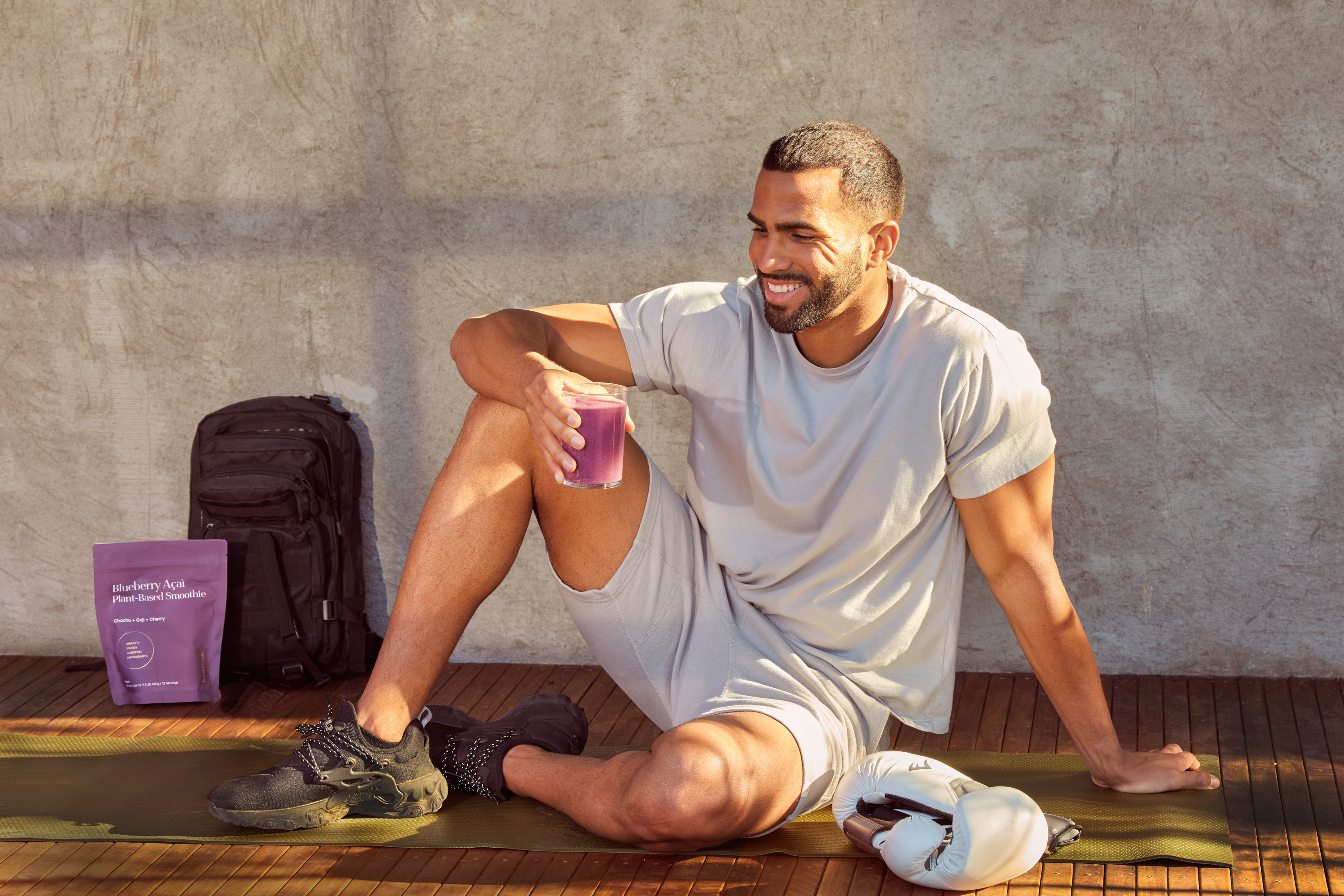 A man holding a glass of Blueberry Acai Smoothie.
