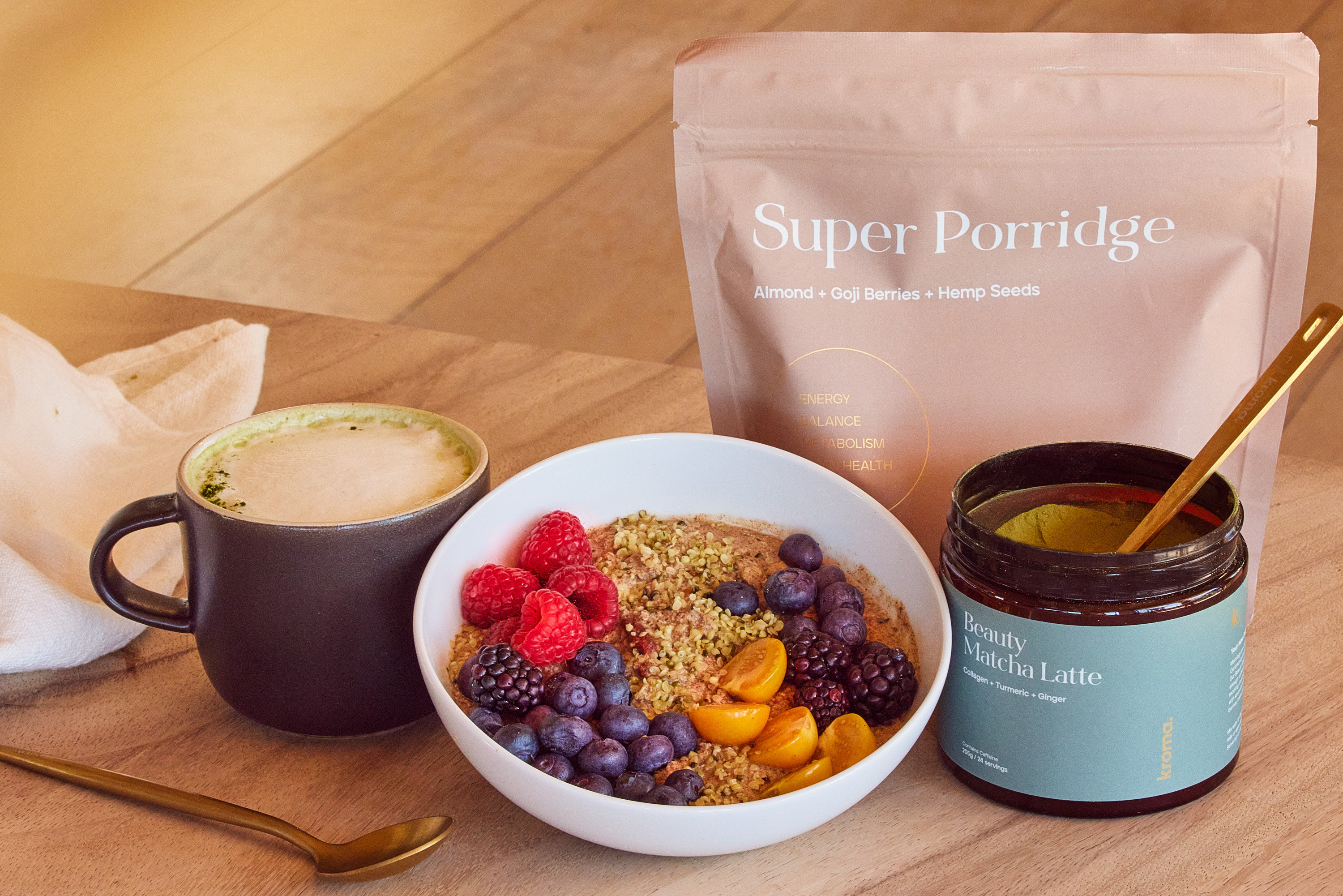 A prepared bowl of Kroma Super Porridge next to a mug of Kroma Beauty Matcha Latte.