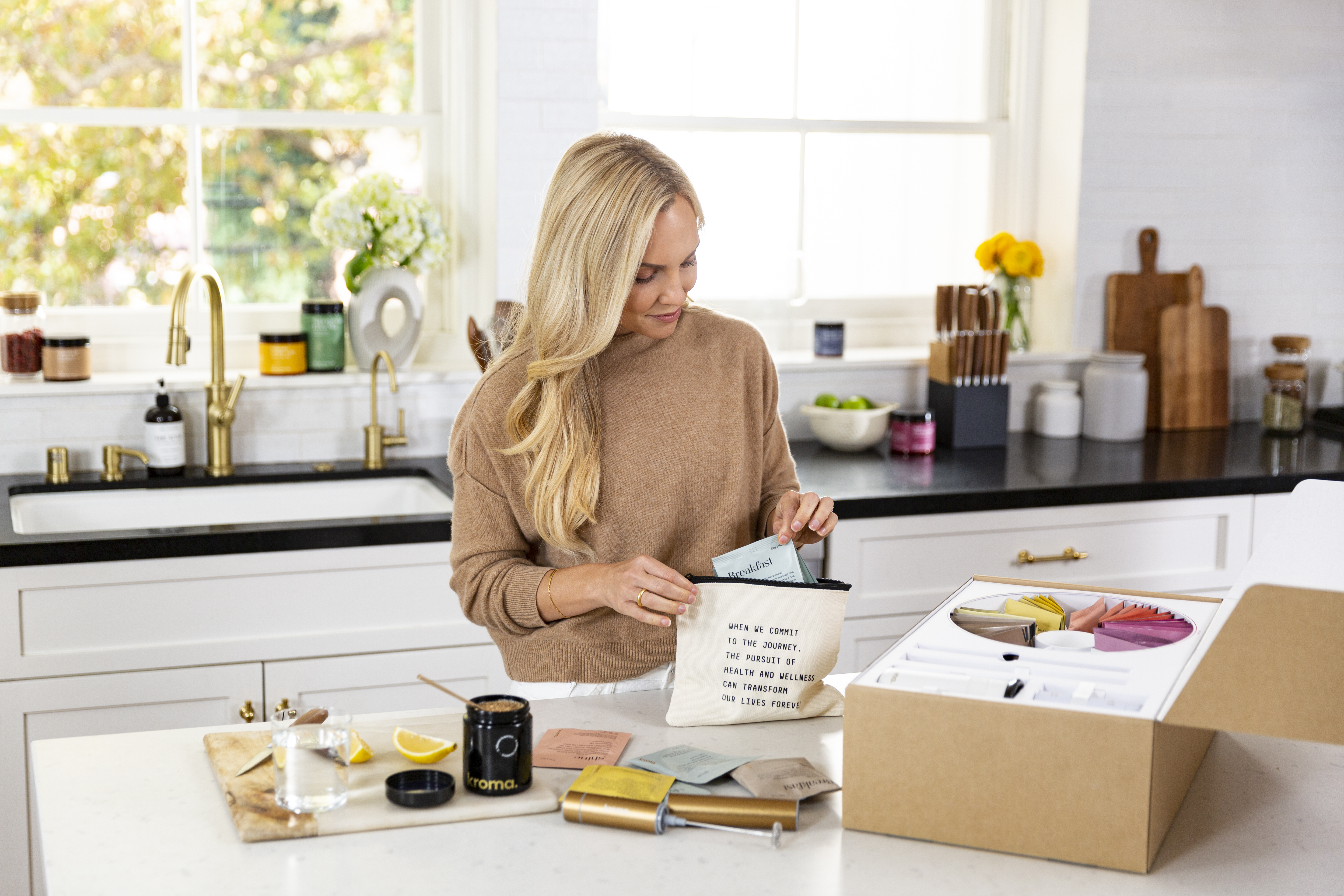 A woman opening and examining items from the Kroma Deluxe 5-Day Reset.