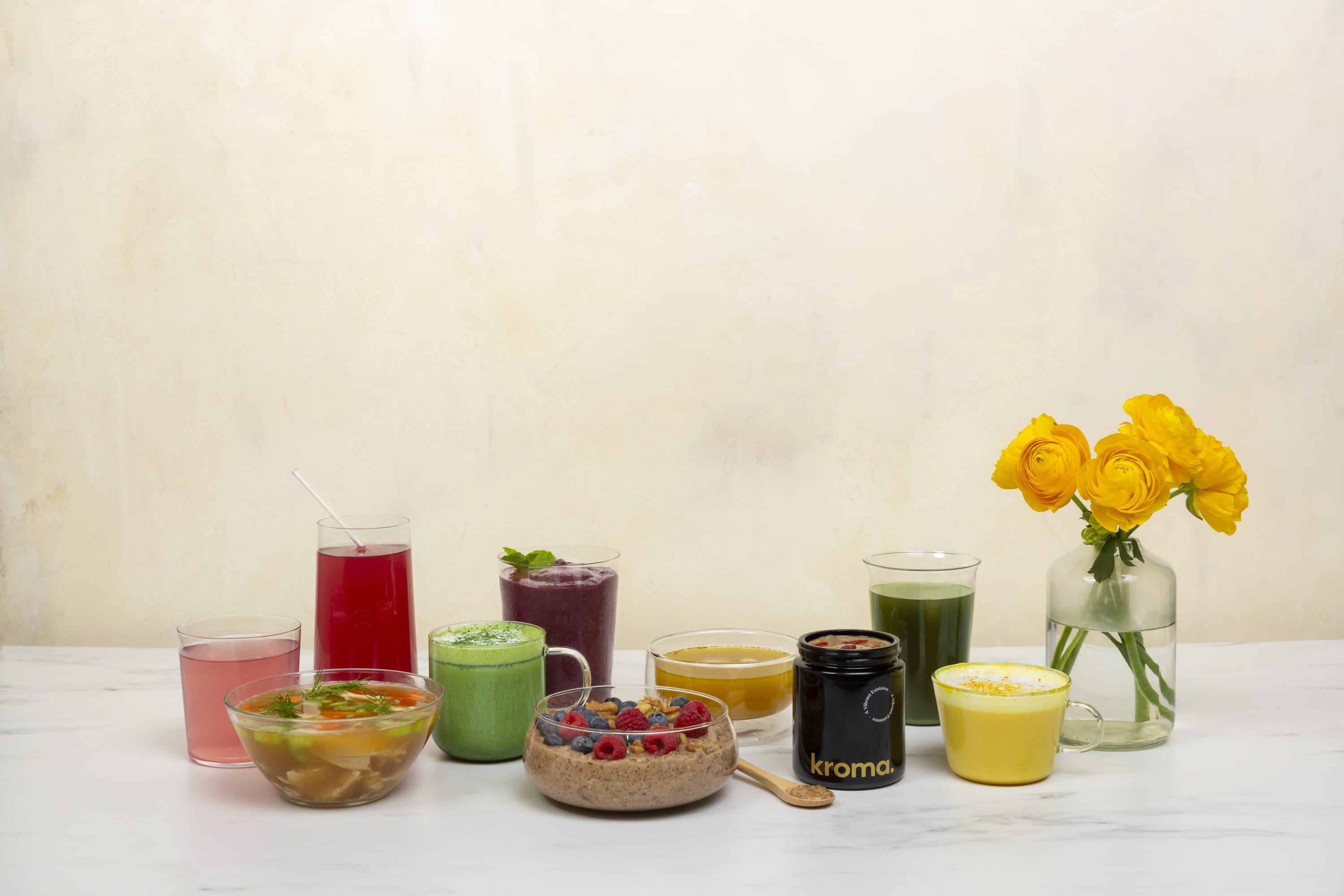 A group of various Kroma Daily Essentials in glasses, mugs, jars and bowls.