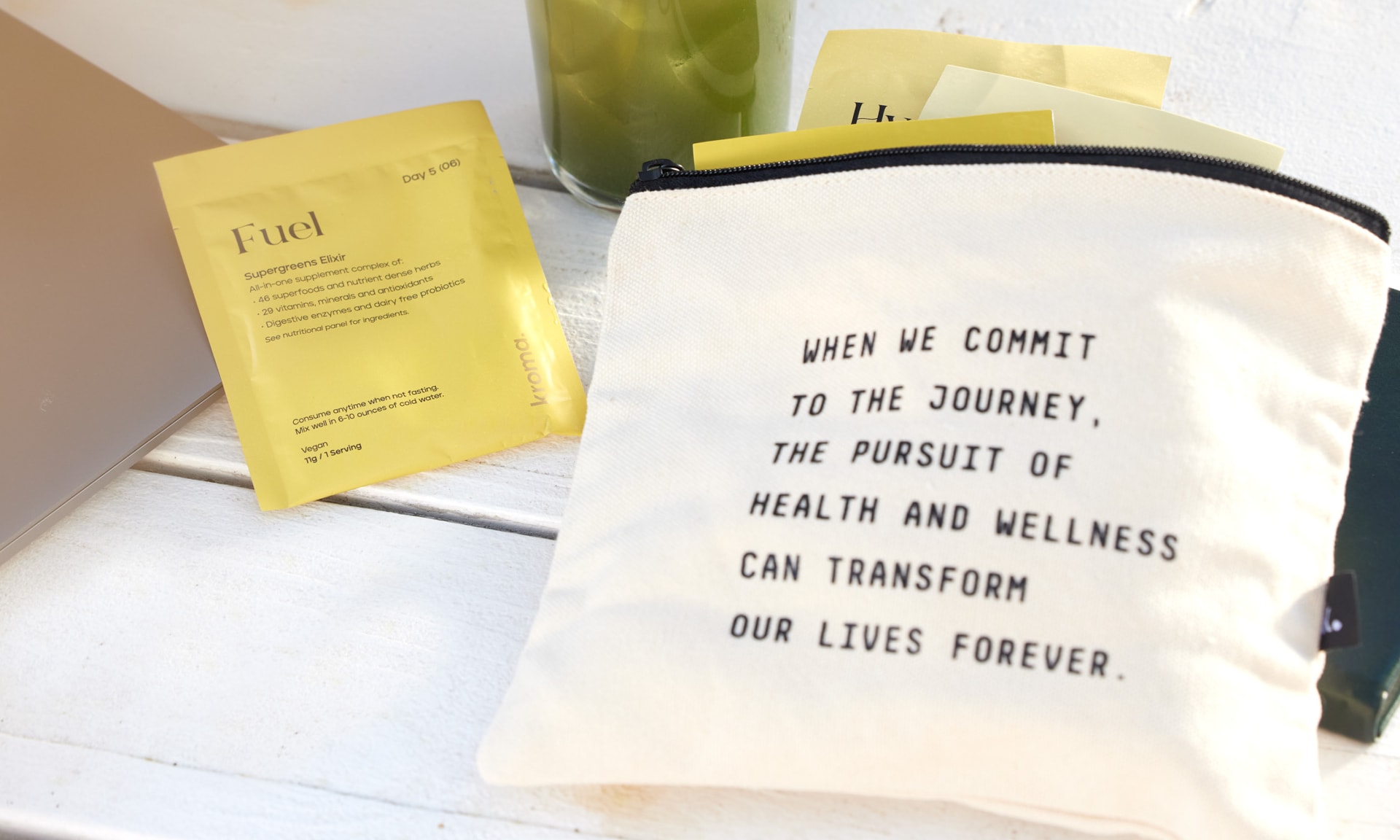 A Kroma Supergreens Elixir sachet next to a Kroma inspirational Zipper Bag.