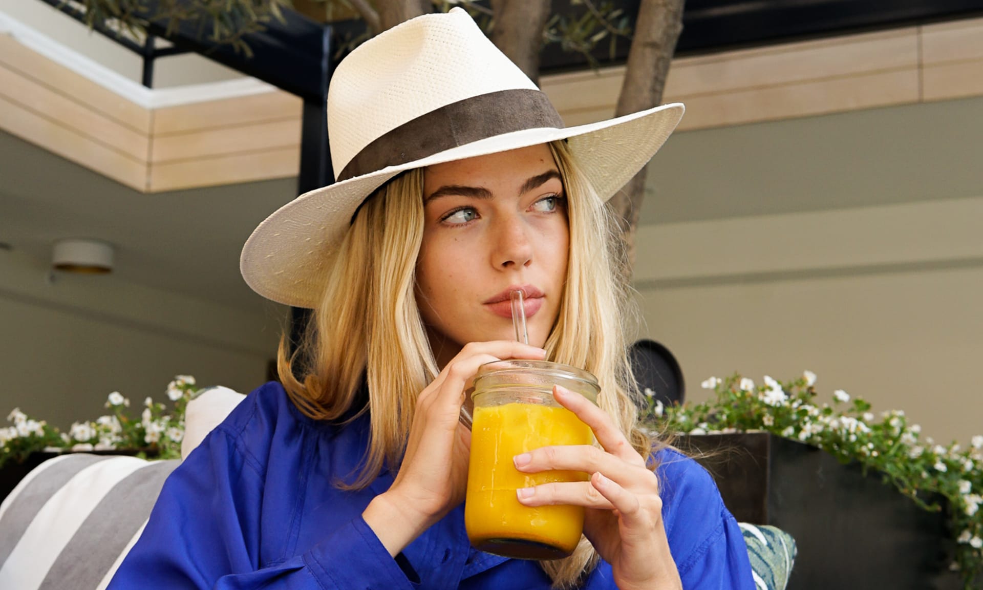 A woman drinking a Kroma Wellness Ultimate Vitality Latte drink that promotes sustainable nutrition.