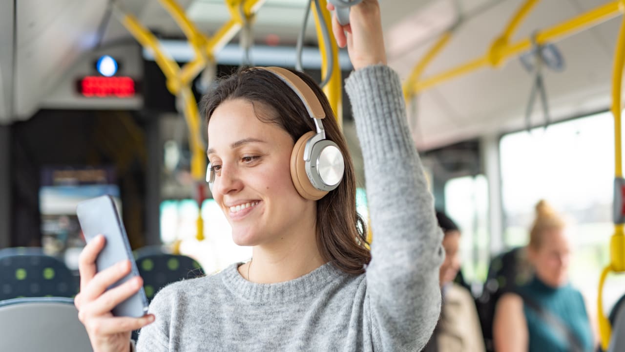 Kvinne med mobil på buss