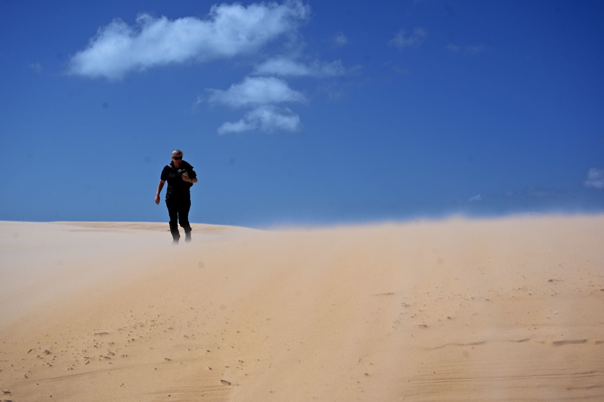 Kiersten struggling back against the strong winds and driven sands