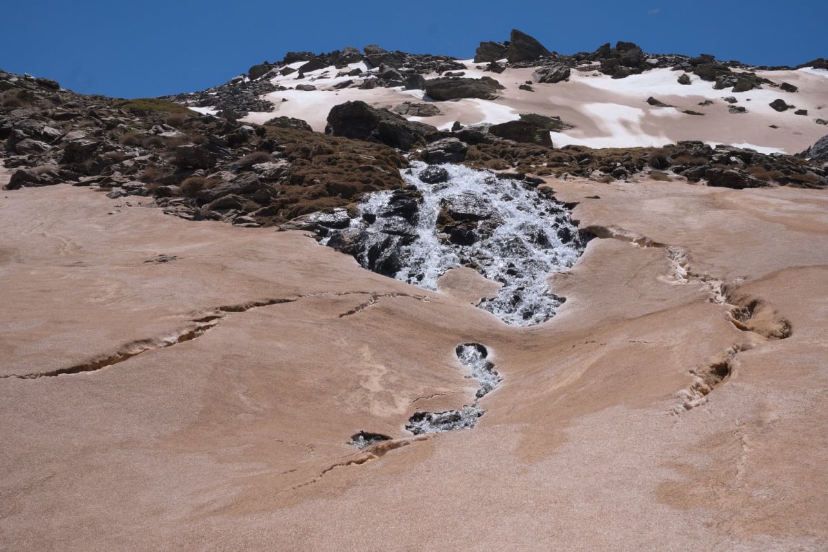 The collapsed snow bridges under the waterfall below the lake