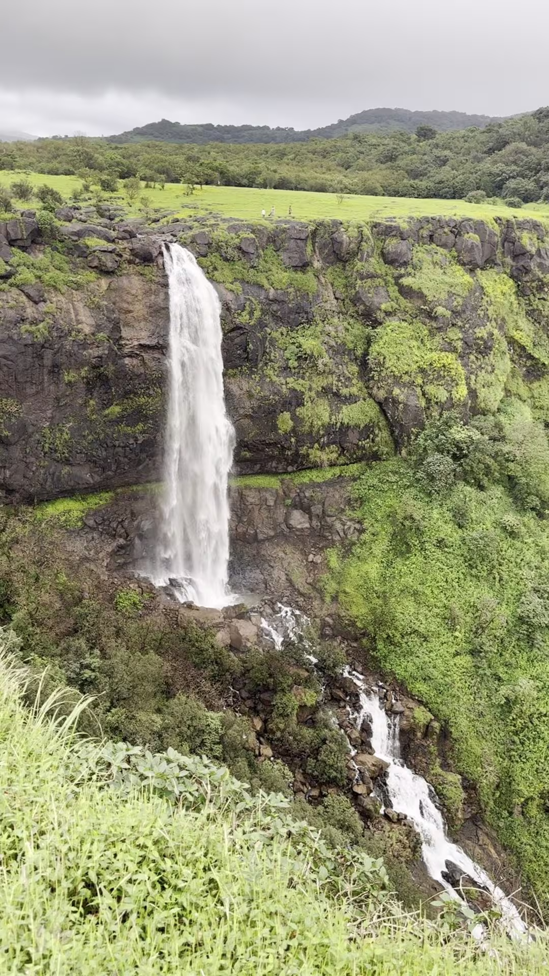 Monsoon waterfall at Madhe Ghat with lush green Sahyadri hills and cliff face