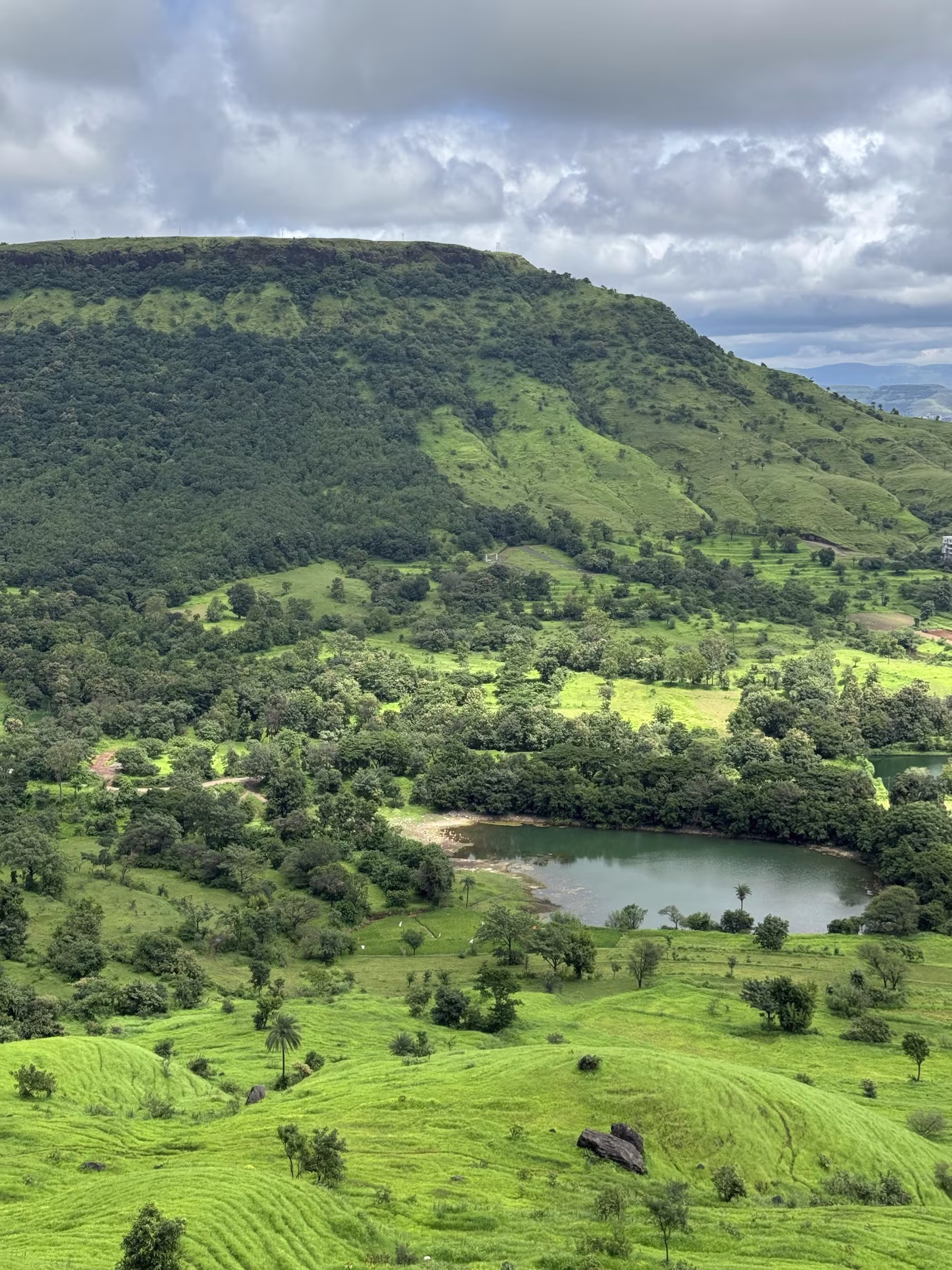 Lush green Sahyadri hills, mountain lake, and winding valley roads on the ascent toward Kaas Plateau in Satara