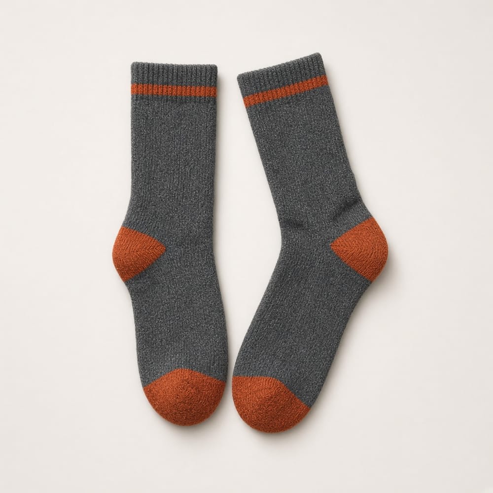 A pair of charcoal trekking socks with orange heels and toes