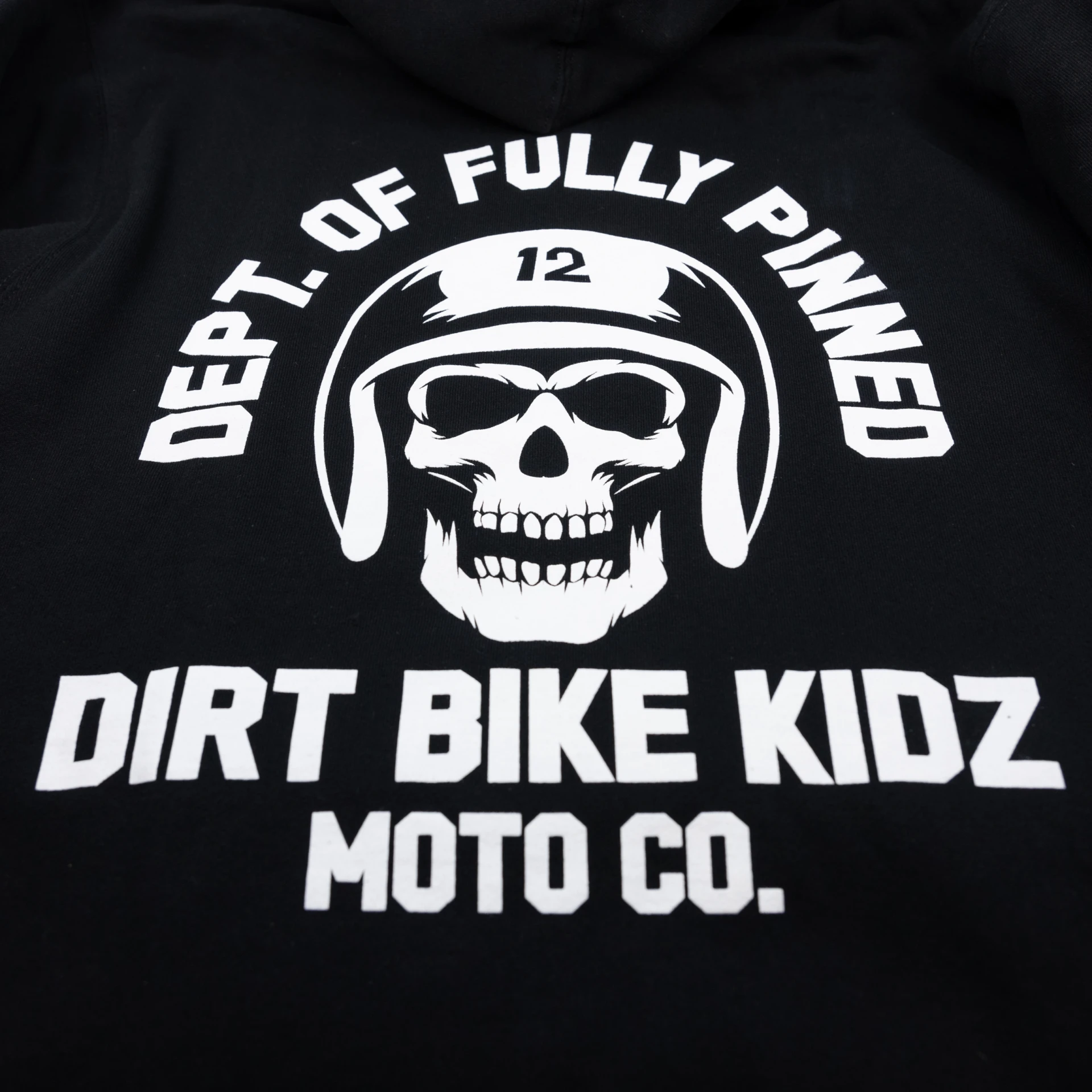 Close-up of the white Dept. of Fully Pinned skull graphic on the back of the black DBK hoodie