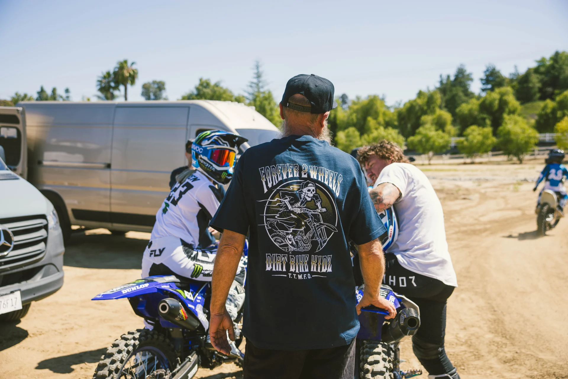 DBK Ghost Rider Tee in navy worn at a motocross track, back view near riders on dirt bikes